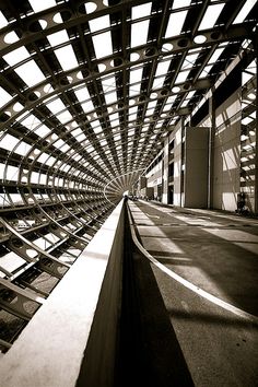 the inside of a building that is made up of metal bars and beams with sunlight coming through them