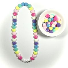 "You have just found the perfect gift for birthdays or Easter! This cute pastel, retro HEART necklace can come personalized or with hearts only. This 16\" stretchy necklace fits right over your head so it's easy to put on- no clasps needed. The matching bracelet is listed here: https://www.etsy.com/listing/909362079/kids-heart-bracelet-party-favor-girls?ref=shop_home_active_5&frs=1 Please check all selections and spelling prior to check out. Our custom jewelry is made to order so all sales a White Necklace With Heart Charm For Birthday, White Heart Necklace For Birthday And Valentine's Day, Fun Pink Necklace For Birthday, Customizable Cute Charm Necklaces For Birthday, Cute Necklace For Birthday And Valentine's Day, Pink Heart Necklace For Birthday, Pink Necklace With Heart Charm For Birthday, Cute Pastel Jewelry For Gift, Cute Pastel Jewelry For Gifts