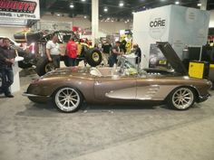 people are looking at an antique car on display