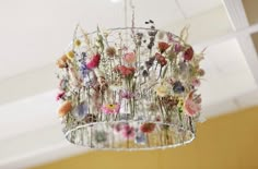 a chandelier with flowers hanging from it's ceiling