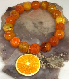 This gorgeous orange 🍊 stretch bracelet is made with stunningly gorgeous 10 mm orange faceted agate beads & is finished off with a realistic looking orange 🍊slice gold plated enamel charm.  It's so bright and beautiful and perfect for the summer🍊☀️🍊☀️.  7 inches in length on 100% polyester stretch cord, not wire. BEADS WILL VARY FROM THE PIC, as this is a made to order bracelet. Handmade Orange Agate Bracelets, Handmade Orange Agate Bracelet, Handmade Orange Bead Stretch Bracelet, Handmade Orange Stretch Bracelet With Round Beads, Orange Stretch Bracelet With 8mm Beads, Adjustable Orange Agate Bracelet, Adjustable Orange Agate Bracelets, Handmade Orange Agate Beaded Bracelets, Handmade Spiritual Orange Stretch Bracelet