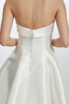 the back of a woman's wedding dress, with buttons and pearls on it