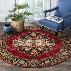 a blue chair sitting on top of a red rug next to a potted plant