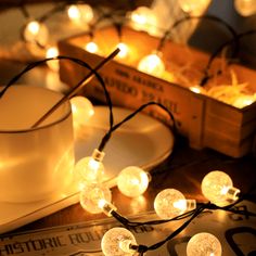 some white lights are sitting on a table next to a cup and plate with saucer