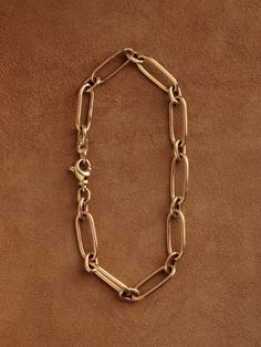 In our quest for the perfect chain—one that could be handcrafted and worn daily, with timeless elegance—we designed and made the Long & Short Chain. Featuring a traditional pattern of elongated, paperclip-style links joined by smaller ovals, this chain lays flat against the arm or chest in a seamless arrangement. Each link is carefully shaped, assembled, and fully soldered by hand in our Burlington studio. The chain is secured with a subtly adorned lobster clasp, designed for durability. On the Gold Chain Bracelet With Hook And Links For Everyday, Everyday Gold Chain Bracelet With Hook And Links, Classic Link Chain Bracelet With Cable Chain, Classic Link Cable Chain Bracelet, Luxury Chain Bracelet With Rectangular Cable Chain Links, Classic Cable Link Chain Bracelet, Modern Oval Link Cable Chain Bracelet, Luxury Paperclip Chain Bracelet, Timeless Chain Link Bracelet