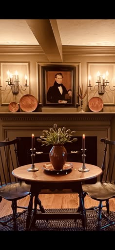 a dining room table with chairs and a potted plant in front of the fireplace