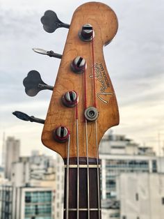 a close up of an electric bass guitar with strings and knobs attached to it