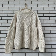 a white sweater hanging on a brick wall