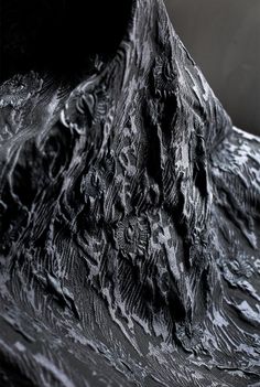 a black and white photo of a mountain with snow on it's face, taken from below