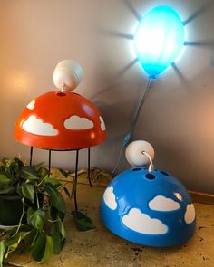 two lamps sitting on top of a table next to a potted plant