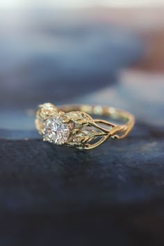 a close up view of a gold ring with a diamond on it's side