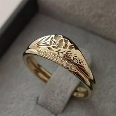 a gold ring with flowers and diamonds on it in a gift box for someone special