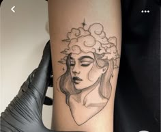 a woman's face with clouds and stars on her head is shown in this tattoo design