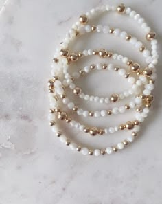 These beautiful Mother of Pearl bracelets with gold-filled spacer beads make for the perfect addition to any bracelet stack. They also would be a stunning addition to a bridal shower or for your bridesmaids. Each one is uniquely different and made with high quality material Cheap Pearl Bracelets, Pearl Bracelet With Words, Bridesmaid Bead Bracelet, Gold And White Bead Bracelet, Silver And Gold Beaded Bracelet, Beaded Gold Jewelry, She’ll Bracelet, Dainty White Stackable Jewelry, Gold Dainty Bracelet With Faceted Beads