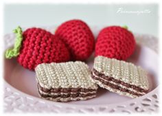 two crocheted strawberries are on a plate