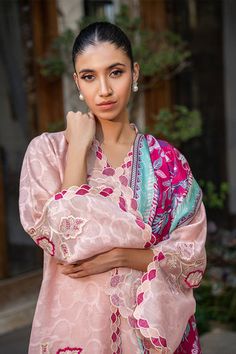 A blush pink cotton net kurta is adorned with scalloped embroidery along the neckline and sleeves and leaf motifs in a mulberry hue. A painterly printed mulberry hued medium silk dupatta is paired with a matching rawsilk trousers. Tissue Silk Dupatta With Dabka, Pink Silk Palazzo Set With Straight Kurta, Pink Slub Silk Palazzo Set With Dabka Work, Silk Palazzo Set With Dabka Work In Pink, Pink Straight Tissue Silk Kurta, Pink Slub Silk Salwar Kameez For Eid, Pink Silk Palazzo Set With Chikankari Embroidery, Pink Slub Silk Set With Sheer Dupatta, Unstitched Pink Slub Silk Salwar Kameez