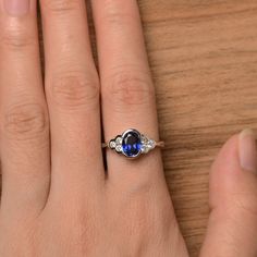 It is a lab sapphire ring. The main stone is 6 mm*8 mm oval cut.weight about 1.75 carats. The basic metal is sterling silver and plated with rhodium. To change the metal to a solid gold (white/rose) or platinum is also available, please ask for a quotation if you want. You can also go to my shop Home for more elegant rings: https://www.etsy.com/shop/godjewelry?ref=hdr_shop_menu Sapphire is the September birthstone. More sapphire rings: https://www.etsy.com/shop/godjewelry?section_id=20715031 Cus Dainty Oval Cubic Zirconia Ring, Oval Sapphire Promise Ring, Oval Cubic Zirconia Sapphire Ring Gift, Classic Sapphire Oval Cabochon Jewelry, Classic Sapphire Oval Cabochon Ring, Classic Sapphire Oval Rings, Blue Oval Birthstone Ring With Halo Setting, Classic Sapphire Birthstone Ring With Gemstone, Oval Sapphire Solitaire Birthstone Ring