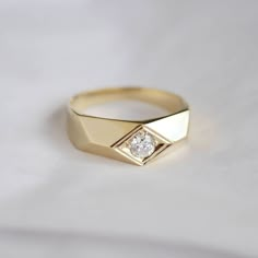 a diamond ring sitting on top of a white sheet