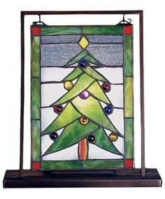 a stained glass christmas tree hanging on a shelf