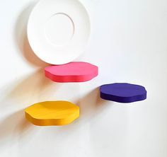 three different colored plates sitting on top of a white table next to each other,