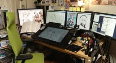 a desk with multiple computer screens and various art work on it, including two monitors