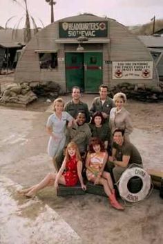 a group of people standing next to each other in front of a green frame with the words china beach on it