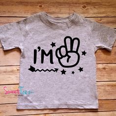 "\"I'm 2\" birthday tee. So cute and funny for your little one's second birthday, for regular wear or perfect as a gift. For a 3rd birthday tee: https://www.etsy.com/listing/546602427/birthday-shirt-im-3-shirt-third-birthday?ref=shop_home_active_1 ➜➜ To upgrade to LONG sleeves: https://www.etsy.com/listing/538047040/upgrade-to-long-sleeve-for-a-black-or?ga_search_query=upgrade&ref=shop_items_search_1 Please choose your shirt color by reviewing our color chart in the 2nd photo of this listing Fun Graphic Print T-shirt For First Birthday, Cute Birthday T-shirt With Funny Text, Playful Letter Print Tops For Birthday, Cute Birthday Top With Crew Neck, Summer Birthday Top With Cartoon Print, Cute Crew Neck Top For Birthday, Summer Cartoon Print Tops For Birthday, Cute Cartoon Print Tops For Birthday, Graphic Tee For First Birthday With Short Sleeves