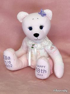 a white teddy bear sitting on top of a pink background with the name ella written on it