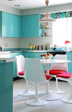 an image of a kitchen setting with blue cabinets and red chairs on the countertop