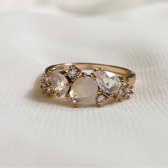 three stone ring sitting on top of a white cloth