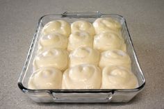 a glass dish filled with white icing on top of a counter