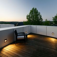 a chair sitting on top of a wooden floor next to a light filled balcony area