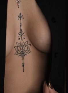 a woman's breast with a tattoo design on her left side, and an arrow in the middle