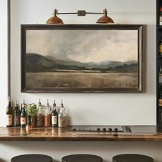 a painting hanging on the wall above a bar with four stools in front of it