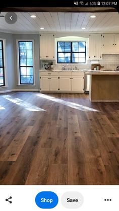 an empty kitchen with wood floors and white cabinets