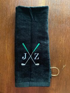 a towel with two crossed golf clubs and the word jz on it is sitting on a wooden table