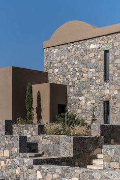 the building is made out of stone and has plants growing on it's sides