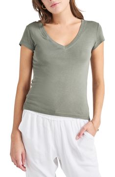 Achieve a casual-cool vibe in this soft cotton-blend T-shirt designed with a dipped neckline and abbreviated sleeves. 23 1/2" length (size Medium) V-neck Short sleeves 60% cotton, 40% rayon Machine wash, tumble dry Imported Summer Cotton V-neck Top, Spring Cotton V-neck Top, Basic Cotton V-neck Top For Summer, Casual Stretch V-neck Top With Short Sleeves, Casual Fitted T-shirt For Loungewear, Cotton Stretch V-neck Short Sleeve Top, Fitted V-neck Top For Everyday, Cotton V-neck Top For Summer, Trendy Cotton V-neck Top For Spring