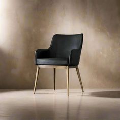 a black leather chair sitting in front of a wall with a light shining on it