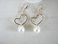 "These hand-formed and hand-hammered 14k gold-filled artistic heart earrings feature beautiful 8mm-9mm WHITE Freshwater Keishi Pearls below. You may choose between Sterling Silver ($55) and 14k Gold-Filled ($65-Shown) and also any other pearl color of your choice by using the drop-down menu at checkout. Choose between: Midnight Blue, Red, Pink, White (Shown), Chocolate Brown, or Champagne. *These are Keishi pearls, which have a more organic shape that features a more-rounded front side and a fla Teardrop Heart Charm Earrings For Wedding, White Open Heart Earrings For Wedding, Open Heart Earrings For Wedding And Mother's Day, White Open Heart Wedding Earrings, Open Heart Wedding Earrings For Mother's Day, Mother's Day Wedding Heart Dangle Earrings, Nickel-free Heart Drop Earrings For Wedding, Nickel-free Heart-shaped Wedding Earrings, Wedding Heart Earrings With Pearl Drop