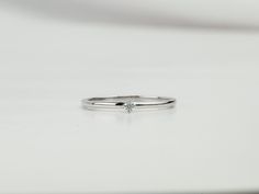 a diamond ring sitting on top of a white table