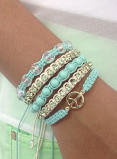 a person wearing bracelets with beads and charms on their arm, both in different colors