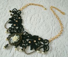 "This beautiful necklace has an antique gold filigree pendant with rose cameo setting, pearl beads, gold plated bead caps, seed beads, metal chain and black lace with rhinestone accents. It is 13\" long adjustable to 17\" long. Lobster clasp." Gothic Filigree Pendant Jewelry, Gothic Filigree Necklaces For Gifts, Gothic Gold Pendant Necklace, Handmade Gothic Necklaces For Formal Occasions, Handmade Gothic Necklace For Formal Occasions, Gothic Handmade Formal Necklace, Victorian Adjustable Brass Necklaces, Victorian Choker Necklace For Formal Occasions, Elegant Brass Jewelry With Decorative Details