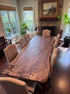 a large wooden table with chairs around it in the middle of a living room area