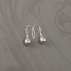 These dainty gray teardrop pearl earrings are made with Swarovski crystal synthetic teardrop pearls and sterling silver beads with sterling silver earring hooks. The earrings are approximately three fourths of an inch long (1.905cm), not including the earring hooks. The earrings will arrive in an attractive gift box. Elegant Adjustable Teardrop Earrings, Pierced Teardrop Pearl Earrings In Sterling Silver, Elegant Adjustable Teardrop Earrings With Pearl Drop, Elegant Gray Earrings With Ear Wire, Elegant Teardrop Earrings With Pearl Drop, Everyday Sterling Silver Teardrop Pearl Earrings, Silver Teardrop Pendant Pearl Drop Earrings, Silver Teardrop Earrings With Pearl Charm As Gift, Silver Pearl Teardrop Earrings As Gift