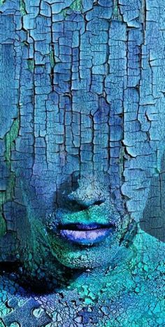 a woman's face is covered in blue and green paint, as if it were cracked