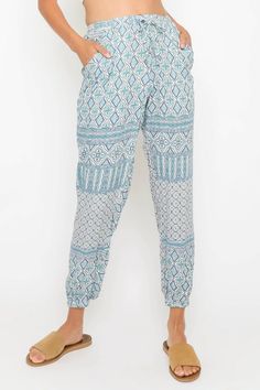 The Francesca Blue and White Boho Print Joggers are the must-have, comfy joggers you need in your wardrobe! Lightweight woven fabric, in a blue, teal, plum, and white bohemian print, shapes these stylish joggers with an elastic, high waist (with drawstring front-tie detail for a perfect fit) atop tapered pant legs with a fitted, elastic hem. Two side pockets, sit below the elastic waist. Blue Printed Bottoms For Vacation, Printed Blue Bottoms For Vacation, Casual Patterned Beach Pants, Summer Patterned Bottoms For Loungewear, Printed Blue Bottoms For Beach Season, Blue Printed Beach Pants, Beach Pants With Printed Blue Design, Blue Bottoms For Beach Season Loungewear, Casual Printed Blue Bottoms