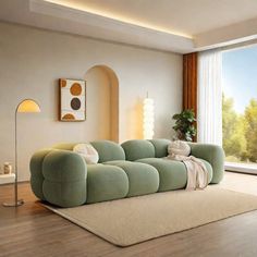 a living room filled with furniture and a large window overlooking the trees in the distance