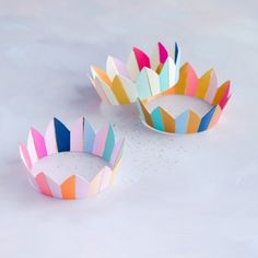 three colorful paper bowls sitting on top of a white countertop next to each other