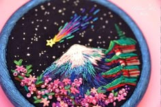 a close up of a small embroidered object on a pink surface with stars and flowers